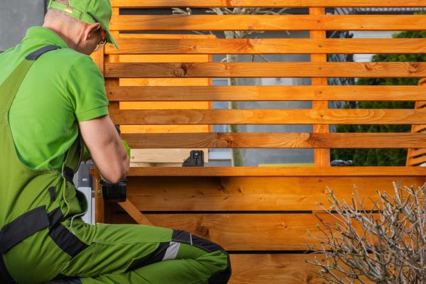 Small Wooden Architecture Building by Caucasian Worker in His 40s. Woodwork Theme.